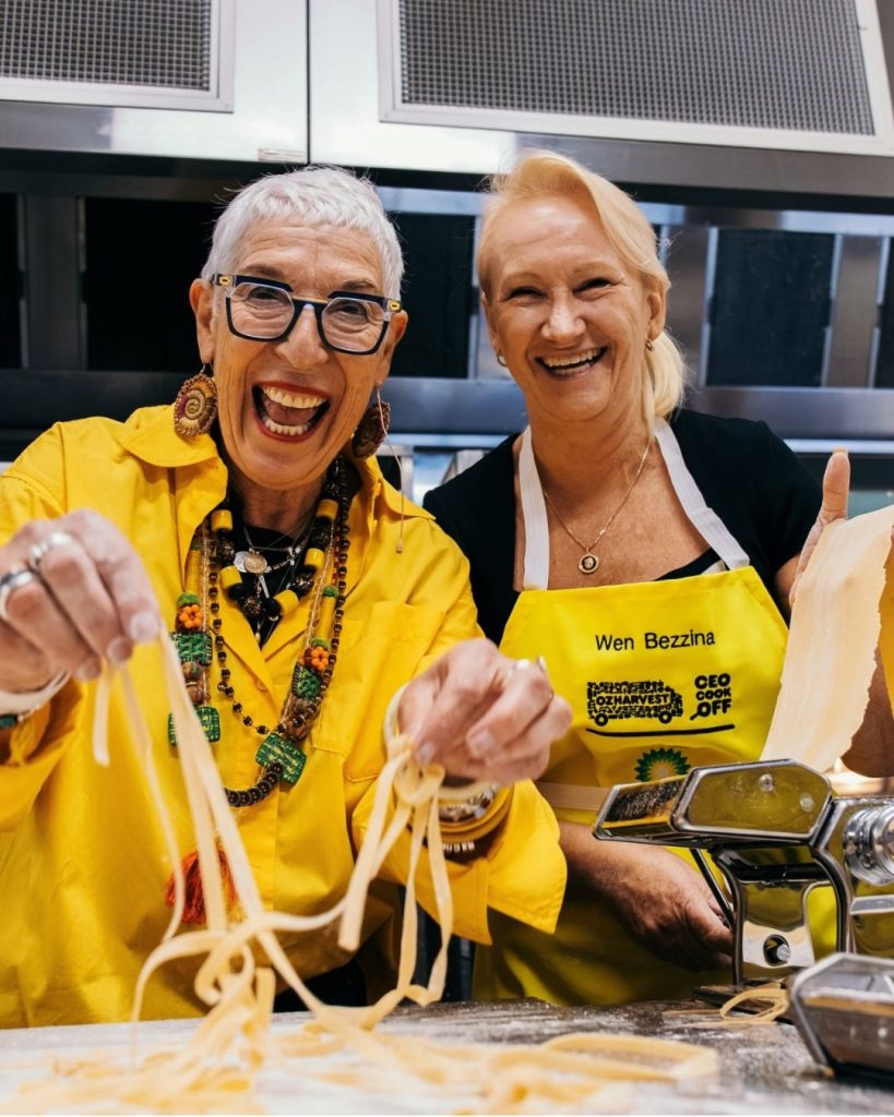 OzHarvest founder laughs making fresh pasta beside volunteer Wen Bezzina at the CEO Cook Off