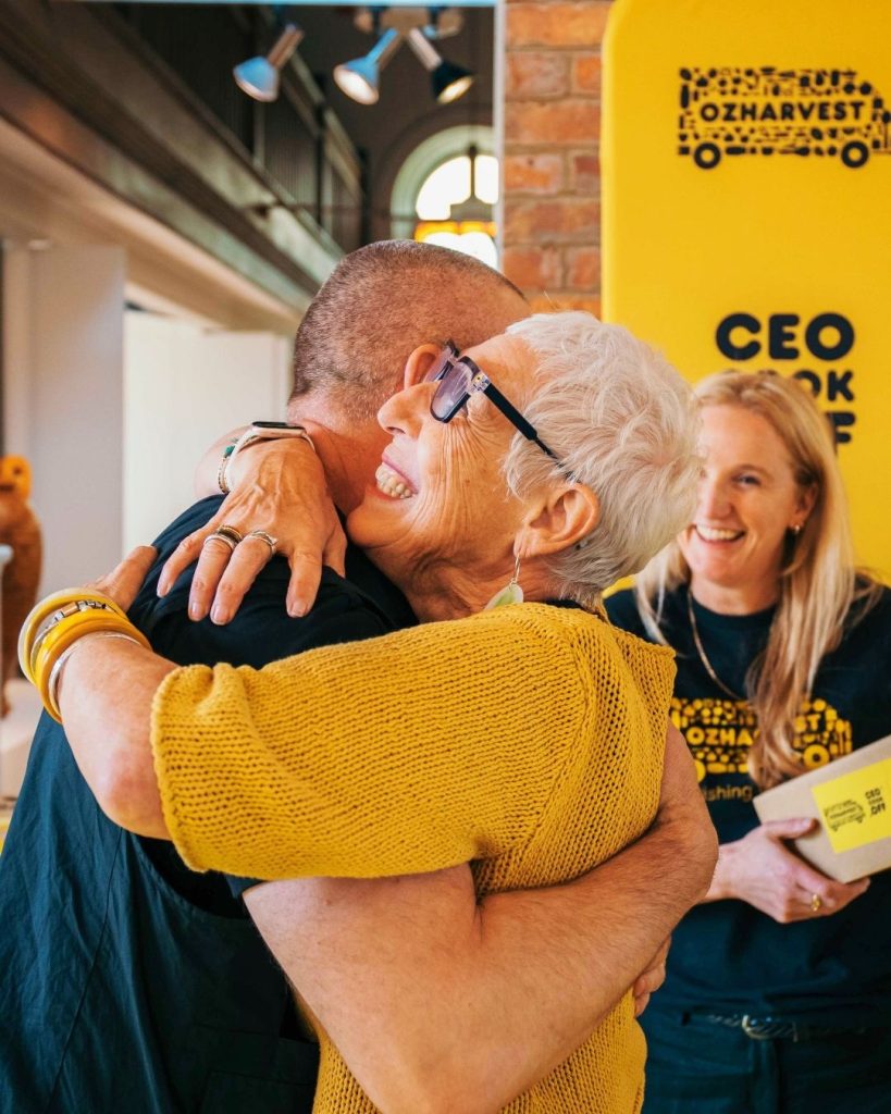 OzHarvest founder shares a warm hug at a yellow CEO Cook Off branded event
