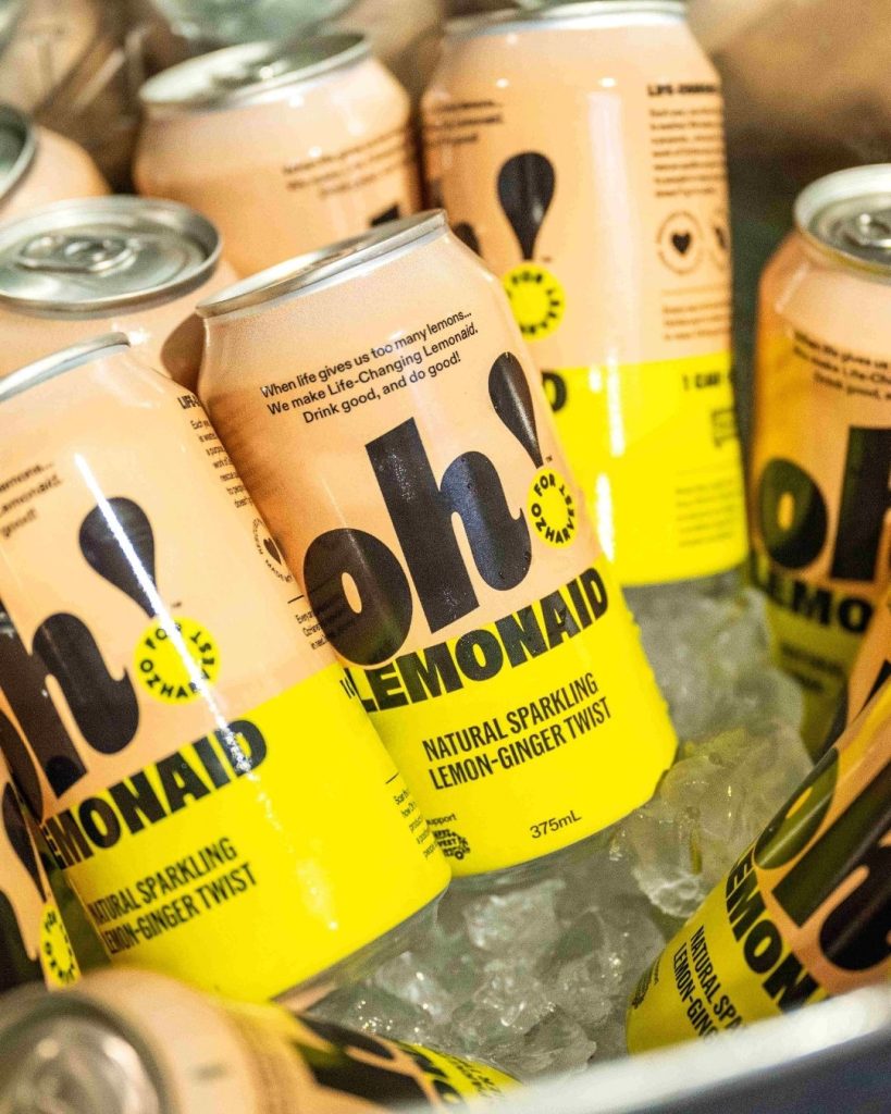 Cans of Oh! Lemonaid natural sparkling lemon-ginger twist chilling on ice in a cooler