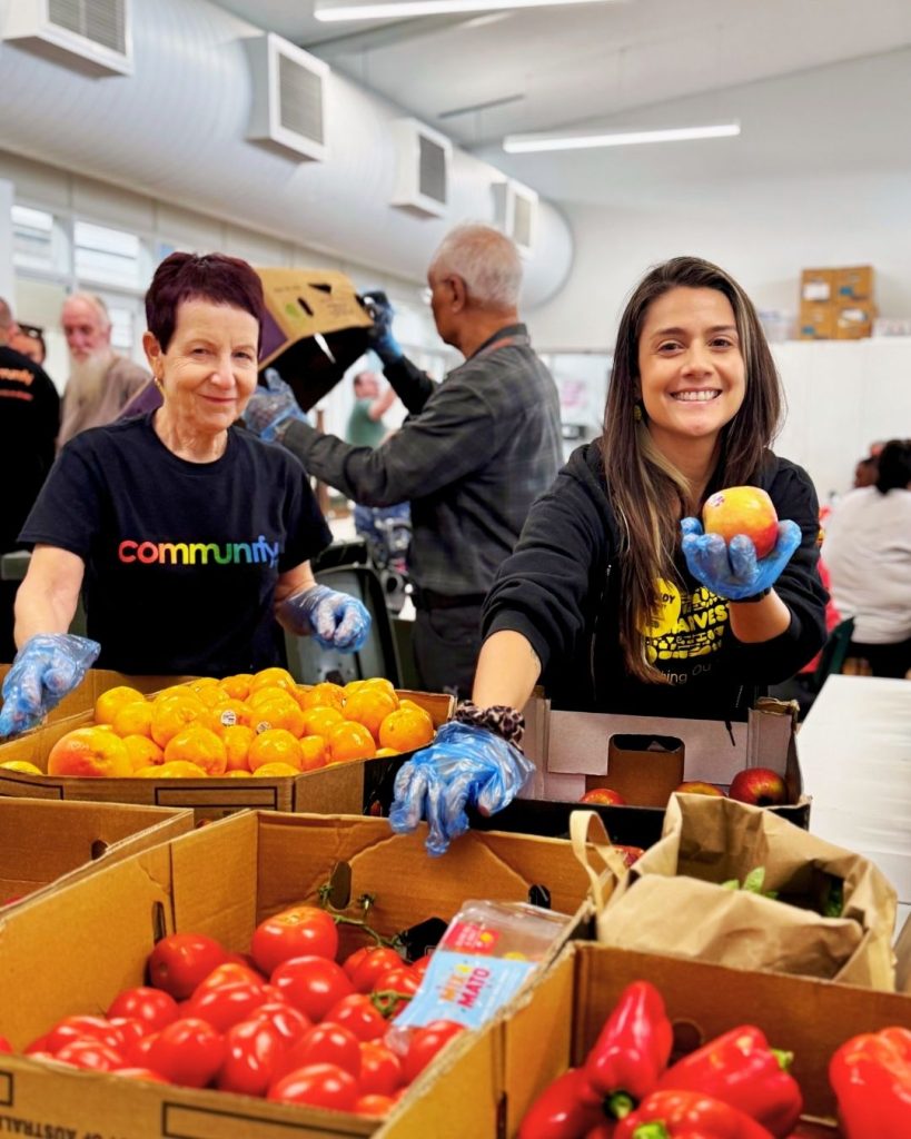 Volunteers sorting rescued tomatoes, peppers and citrus into boxes at a community food hub